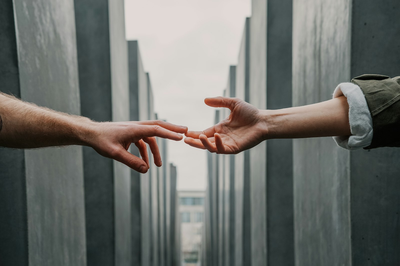 Two hands reaching toward one another, almost touching